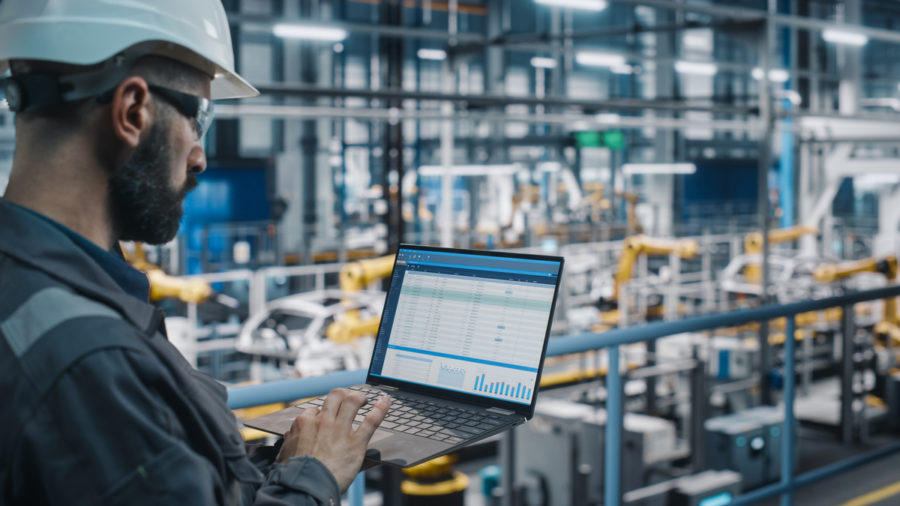 Man holding laptop in factory